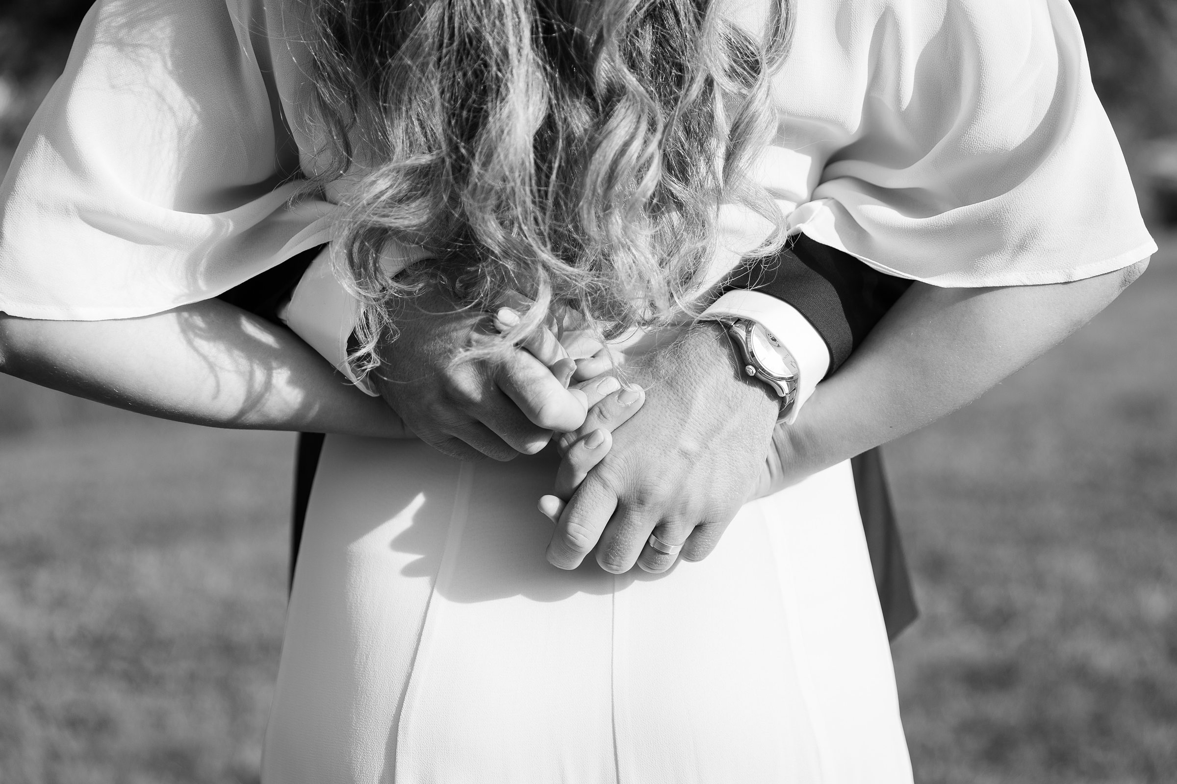 black and white image of bride and groom holding hands 