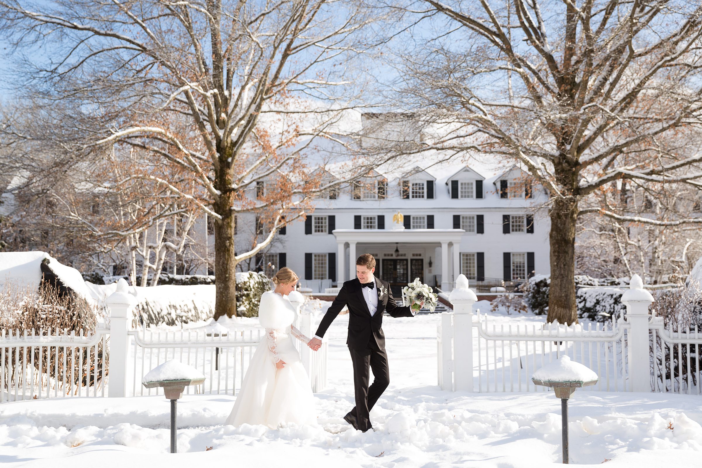 Bride and groom walking hand in hand at winter wedding at the Woodstock Inn