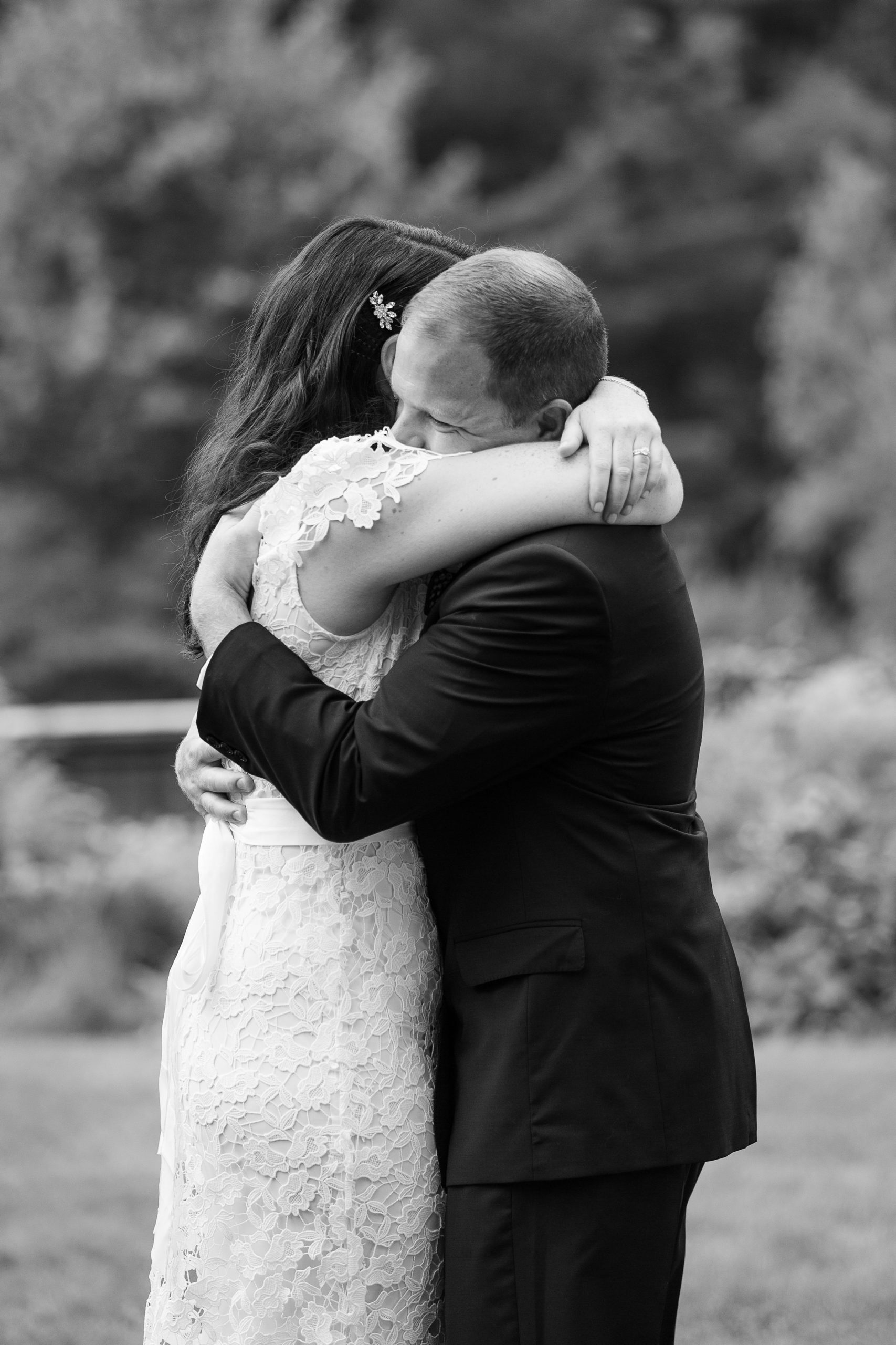 Bride and groom hugging black and white photo during wedding reception