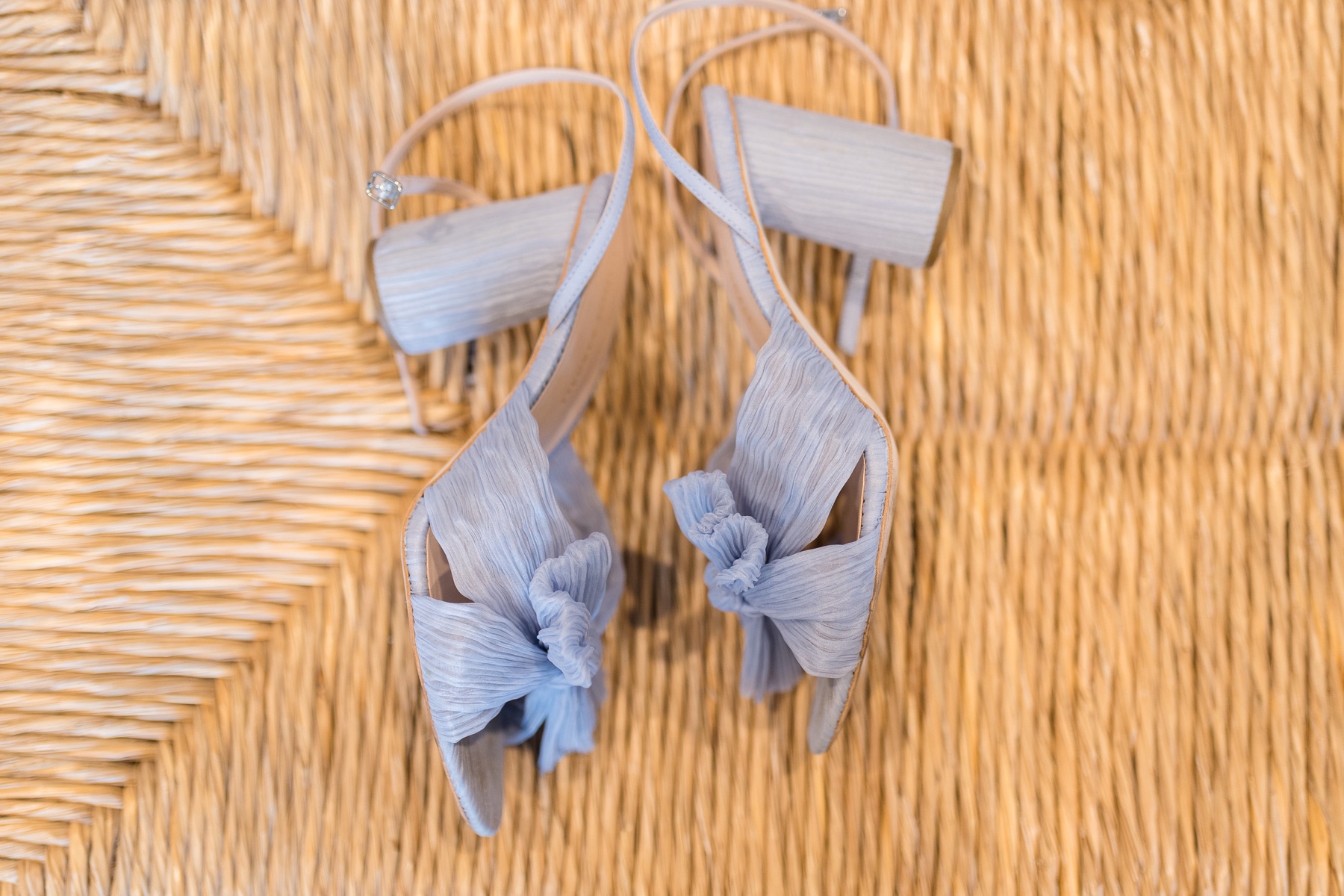 photo of blue wedding shoes sitting on rattan chair