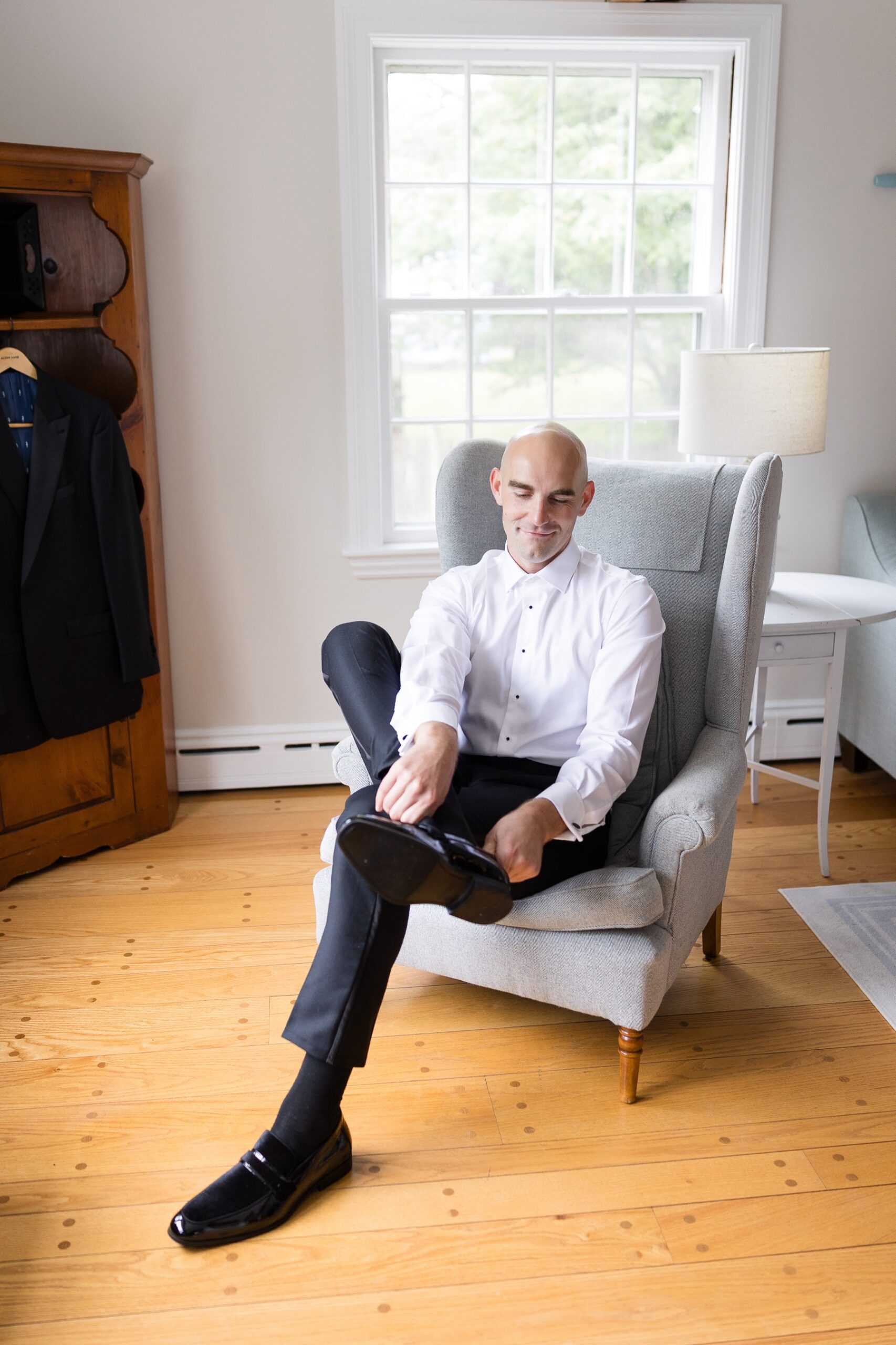 groom sitting in chair putting on his shoes
