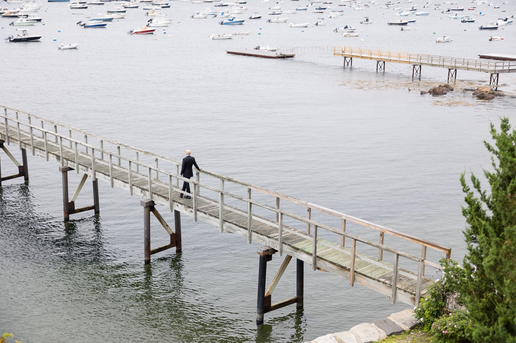 groom standing on pier before first look