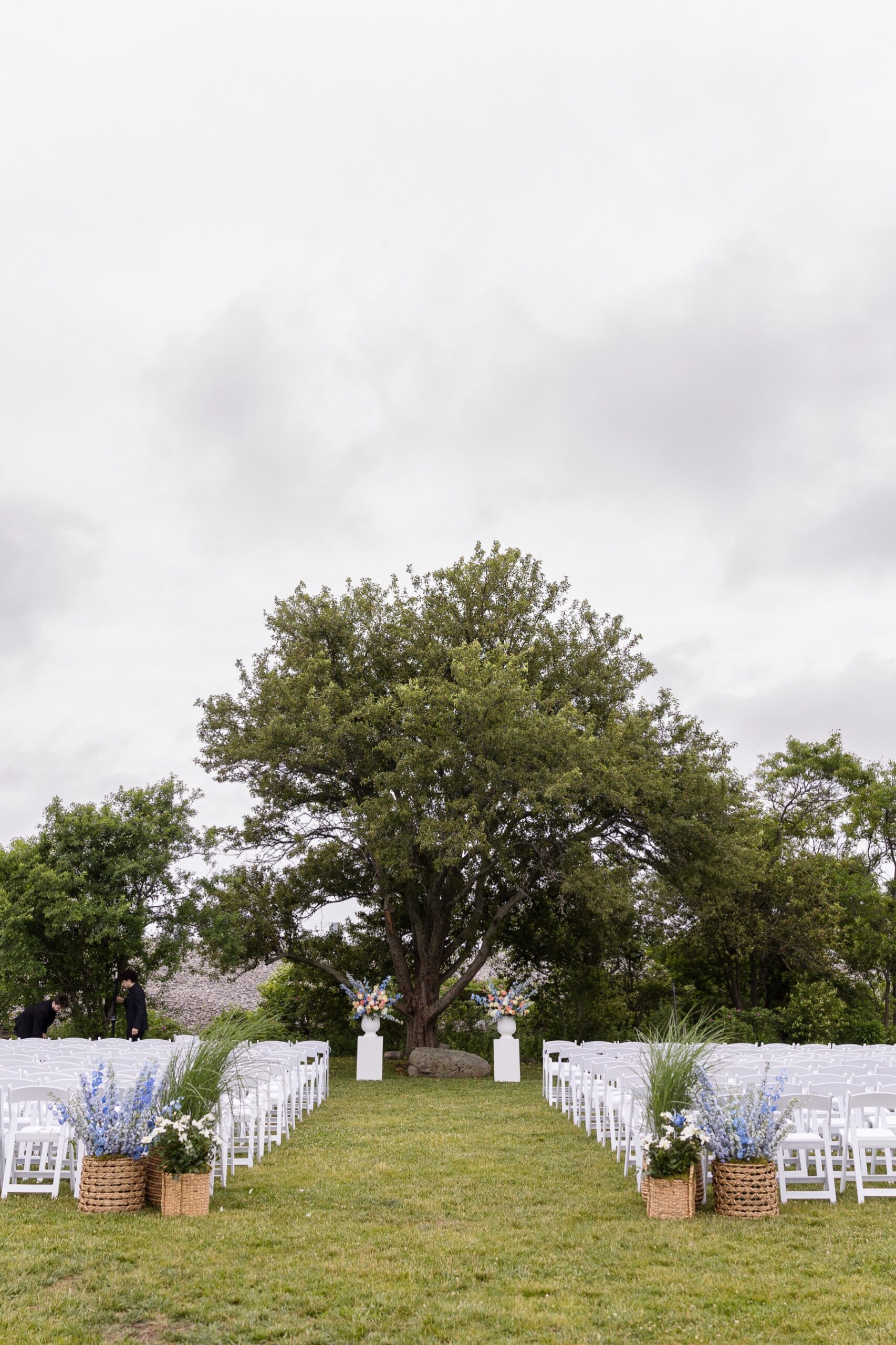 wedding ceremony with white chairs and bright floral arrangements