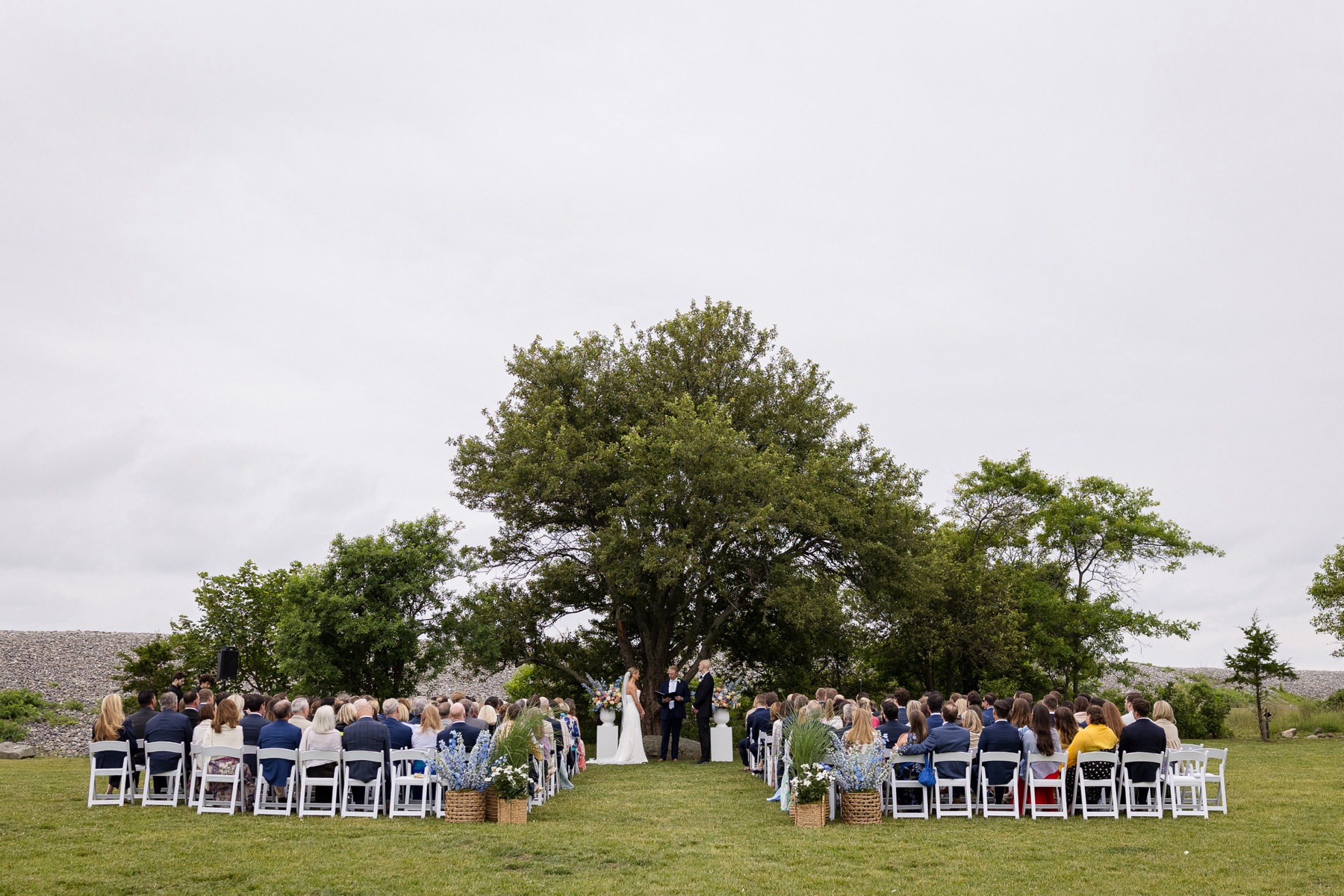 bride and groom standing at the altar surrounded by guests during the ceremony