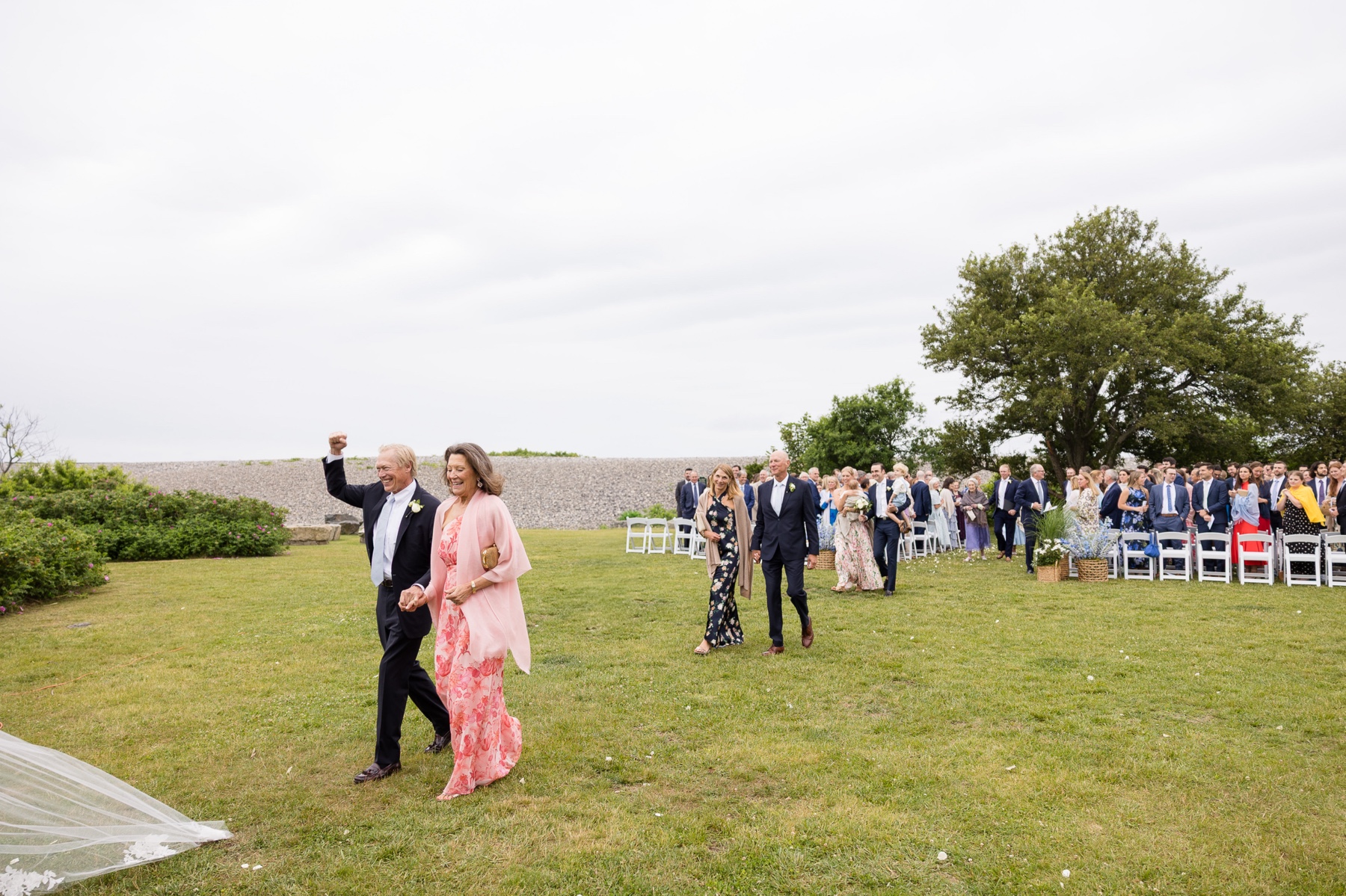 family walking away from the ceremony site to the reception