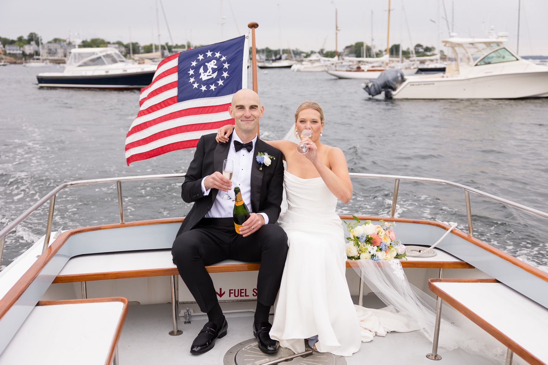 bride and groom drinking champagne on the back of the boat
