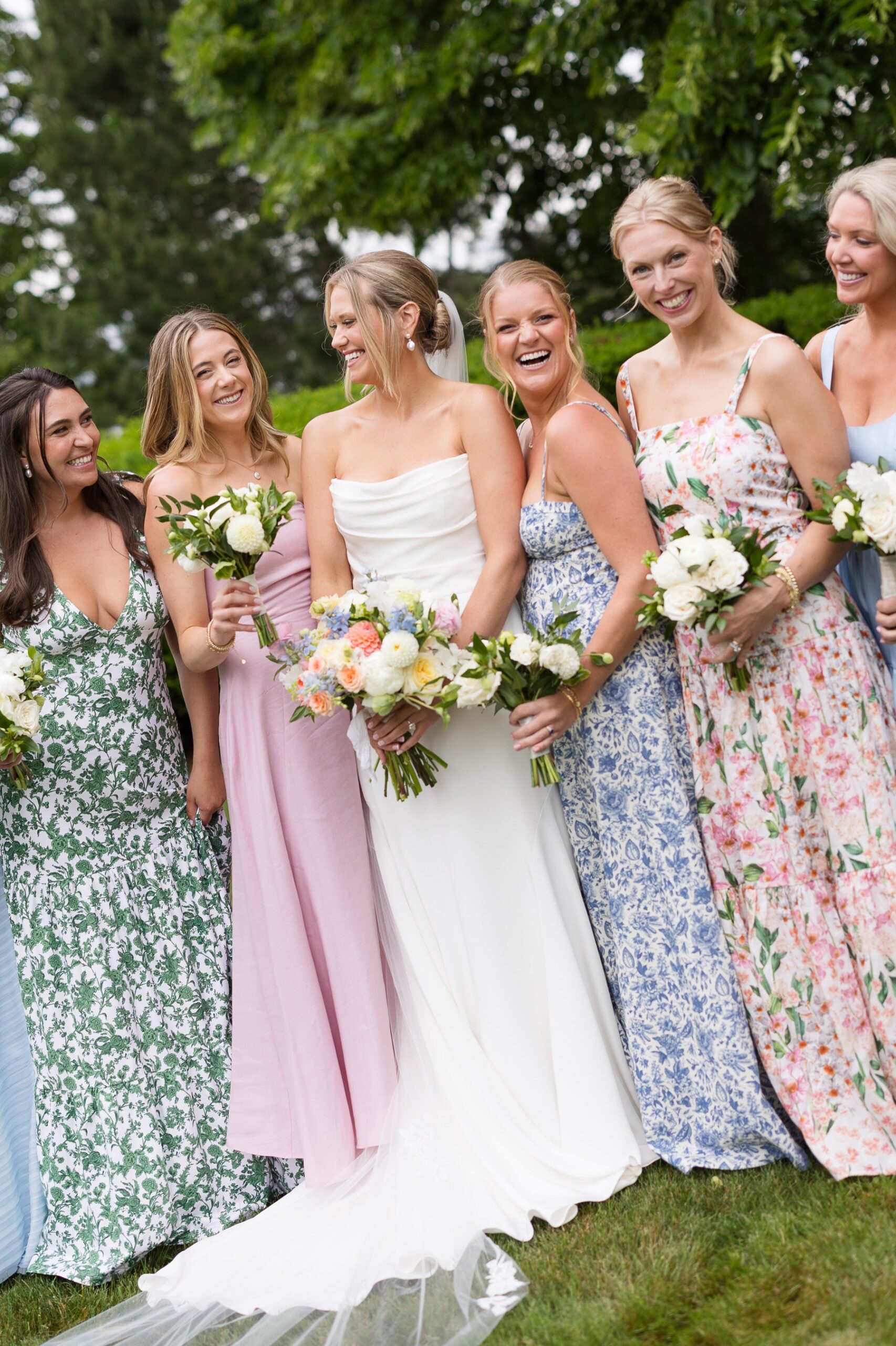 bride and her bridesmaids holding bouquets and laughing