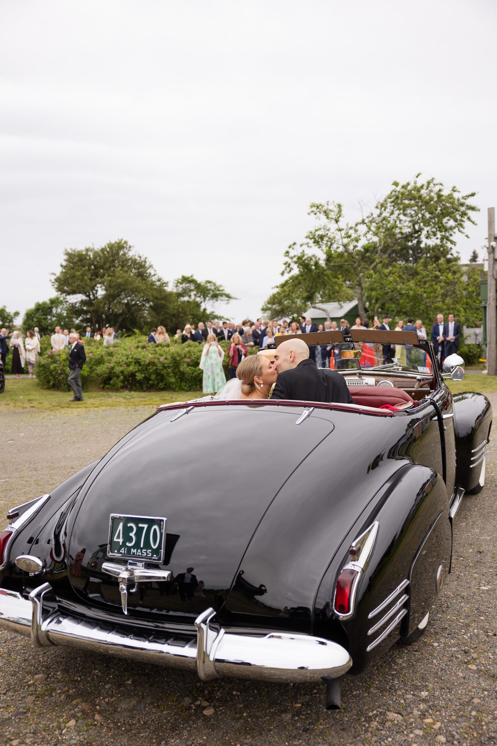 bride and groom arriving to their reception in a vintage car