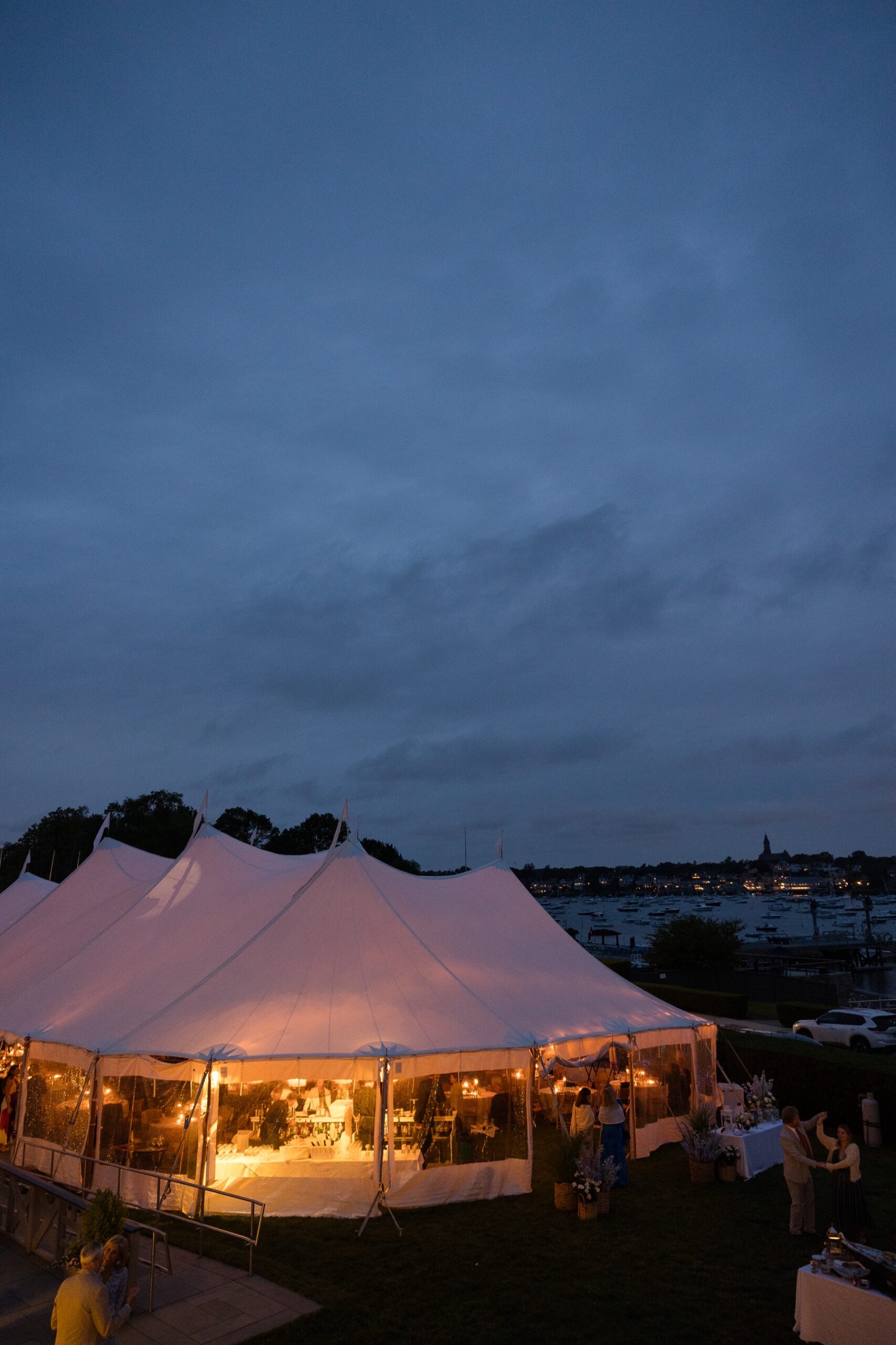 lit up tent during an evening wedding reception at eastern yacht club