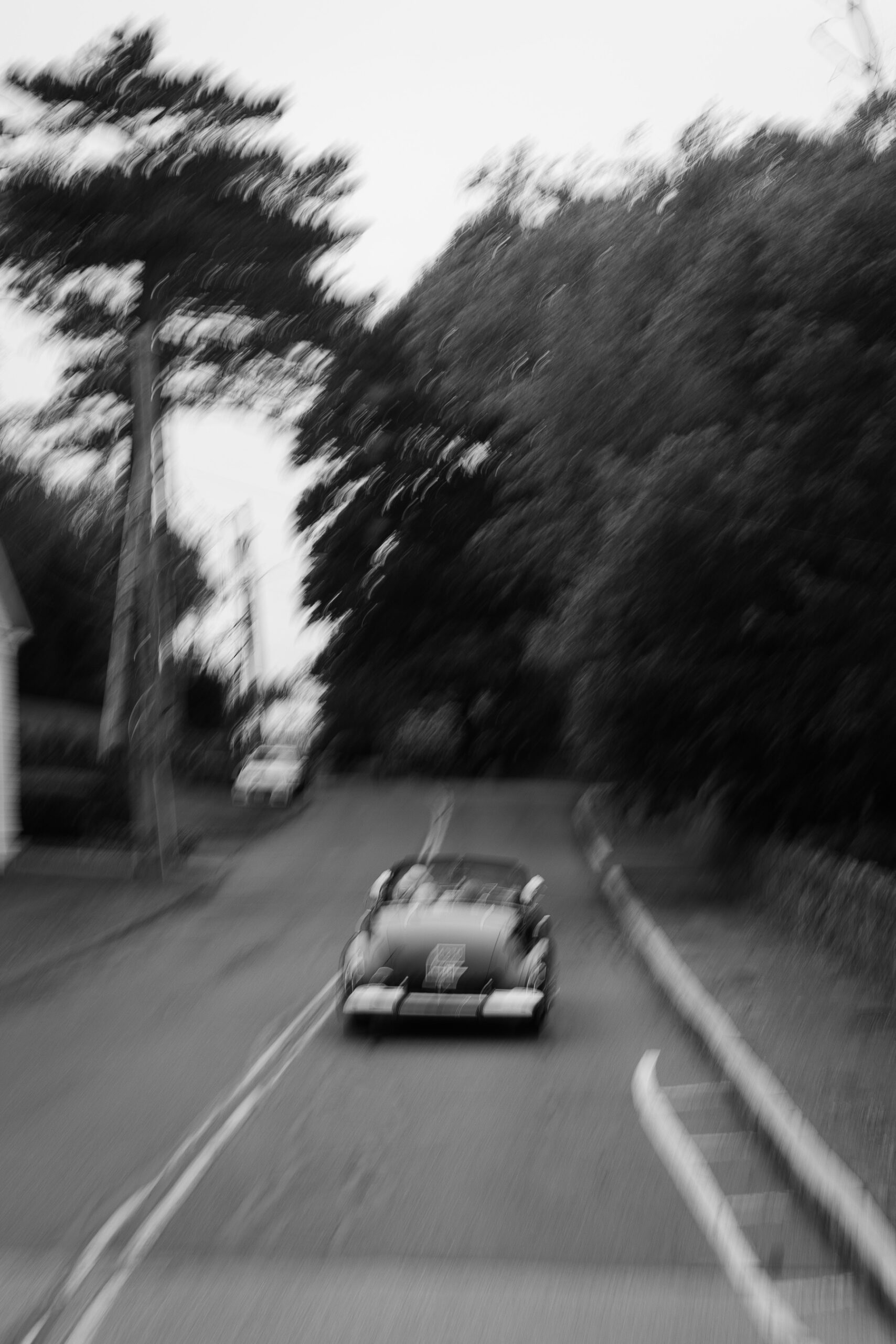 blurry photo of vintage car driving down the road